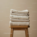 Stack of Neutral Textured Blankets on Wooden Stool