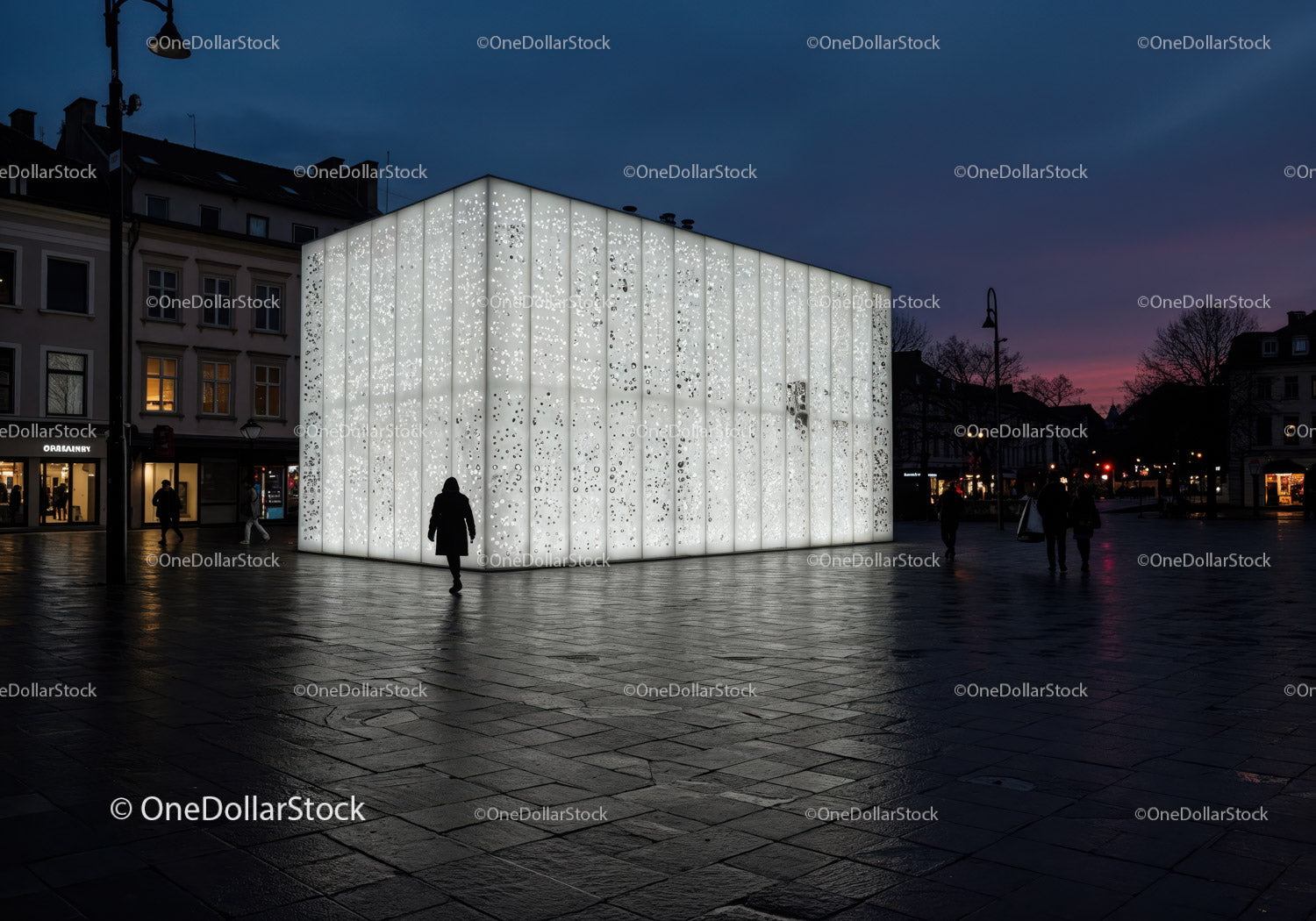 Duża, nowoczesna, podświetlana rzeźba w kształcie sześcianu na placu miejskim nocą