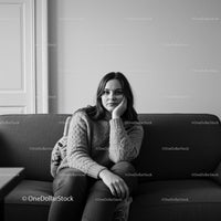 Elegant Woman Sitting on Sofa in Cozy Modern Interior