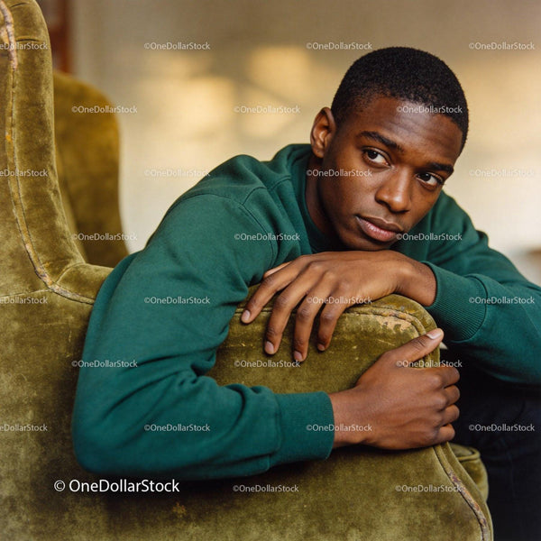 Thoughtful young man resting on vintage armchair