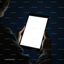 Person Holding Tablet with Bright Screen in Dark Room