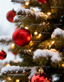 Snow-covered Christmas tree with red baubles and lights