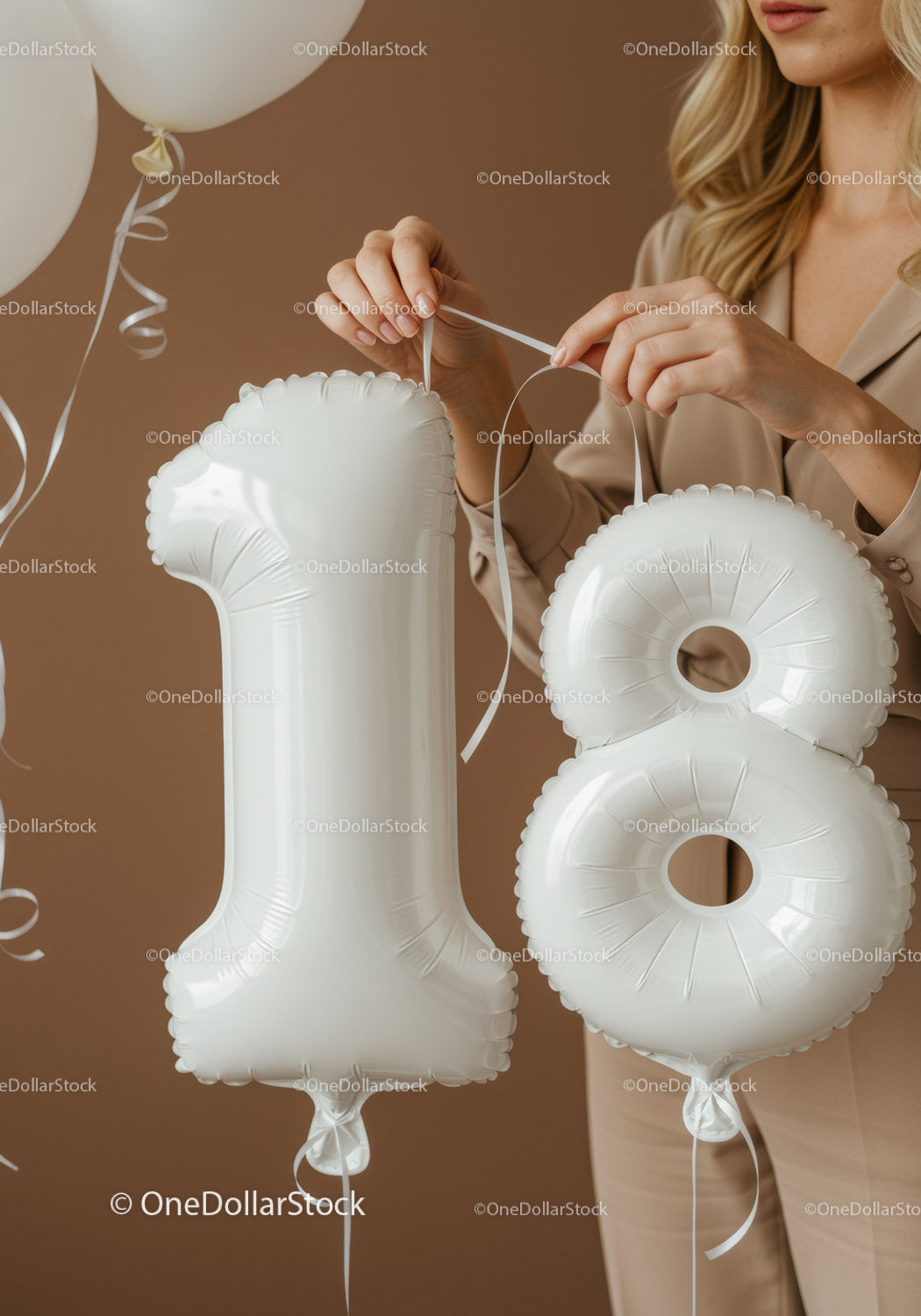 Hands tying white balloons shaped as number eighteen
