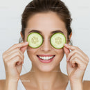 Smiling Woman with Cucumber Slices Over Eyes During Skincare Routine