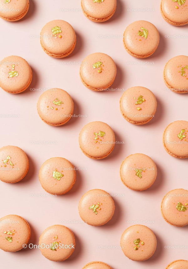 Elegant peach macarons with golden decoration on pink