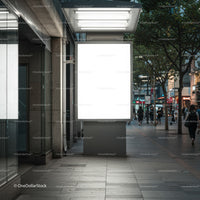 Empty illuminated billboard in urban evening street scene