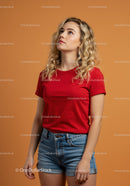 Young woman in red t-shirt looking up thoughtfully