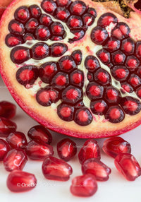 Close up of juicy pomegranate seeds inside fruit half