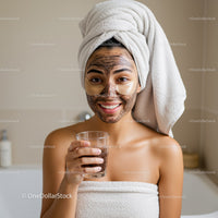 Young Woman Applying Facial Mask with Towel Wrap for Skin Care