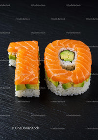Fresh Sushi Rolls Shaped as Number Ten on Black Slate