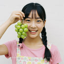 Young Girl Holding Fresh Green Grapes with Happy Smile