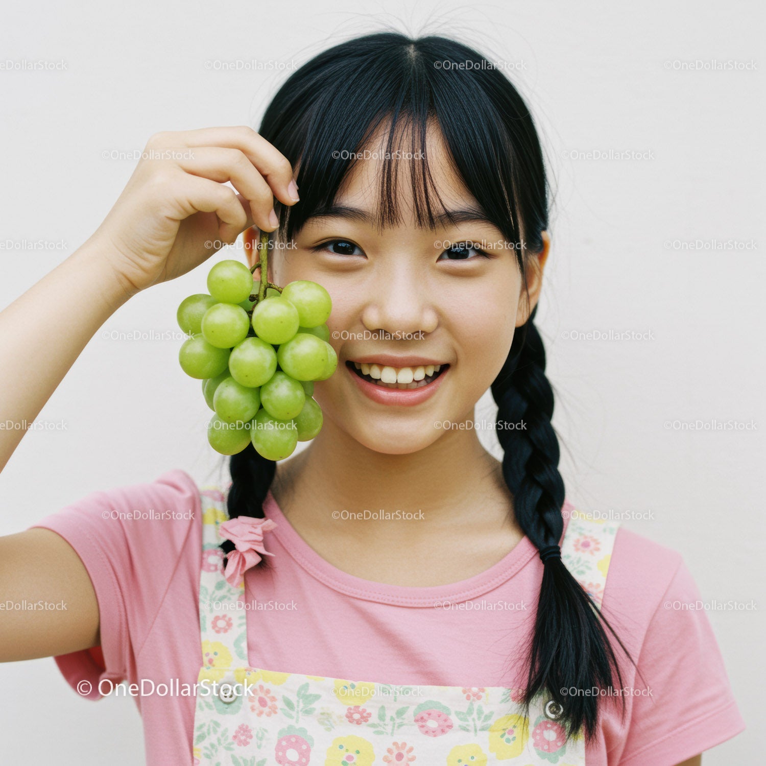 Young Girl Holding Fresh Green Grapes with Happy Smile
