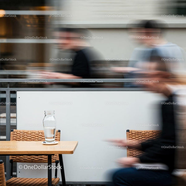 Empty Table with Glass Amid Blurred Moving People JPG Mockup Image