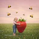 Little Girl Embracing Giant Strawberry in Flower Field