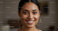 Smiling Woman with Hoop Earrings in Bright Close-Up Portrait