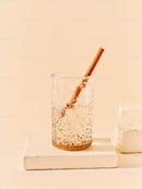 Refreshing sparkling water with cinnamon stick on beige