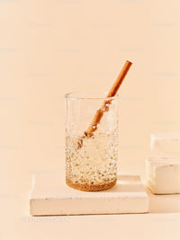 Refreshing sparkling water with cinnamon stick on beige