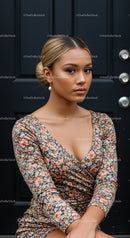 Young woman with floral dress posing against black door