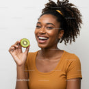Joyful Young Woman Smiling with Fresh Kiwi Fruit in Hand