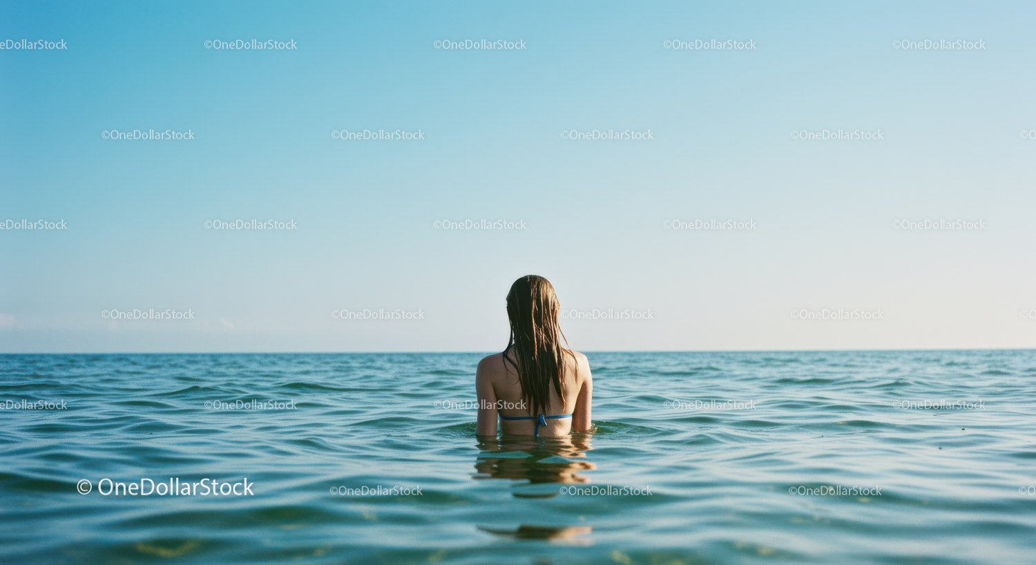Woman Swimming in Calm Ocean Water with Clear Sky in Summer