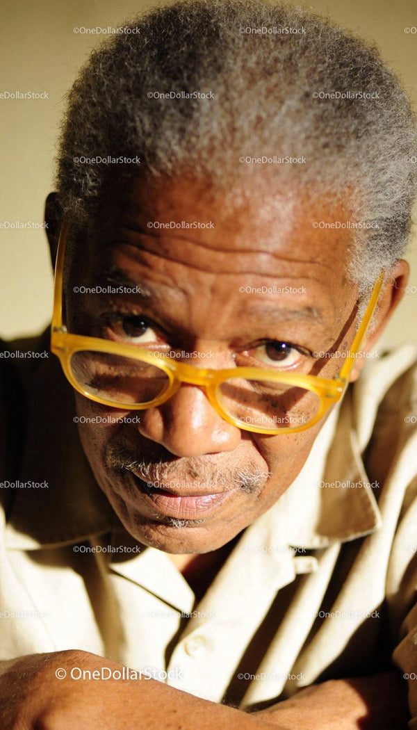 Elderly man with yellow glasses in thoughtful pose