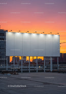 Modern City Skyline with Rooftop Billboard at Sunset