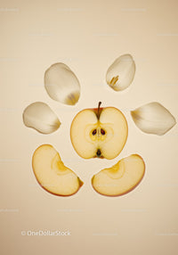 Sliced apple and white flower petals on soft background