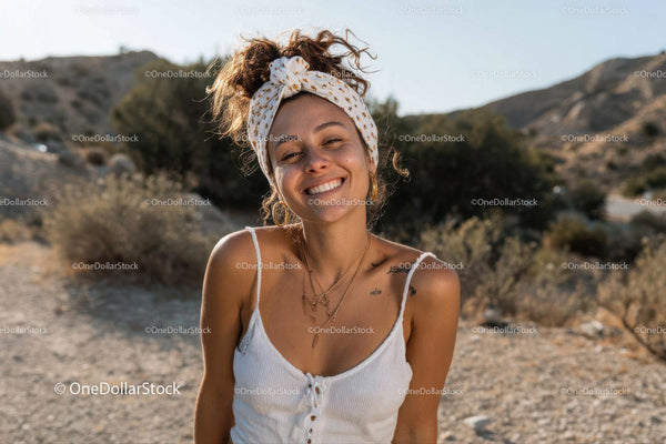 Smiling woman in casual summer outfit standing on dusty desert trail