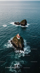 Scenic Sea View with Lighthouse on Rocky Island Under Cloudy Sky