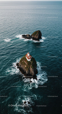 Scenic Sea View with Lighthouse on Rocky Island Under Cloudy Sky
