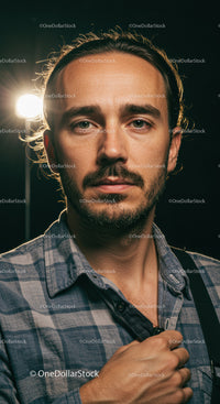 Thoughtful man in plaid shirt with soft studio lighting
