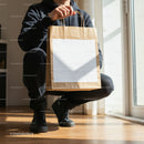 Person Holding Brown Paper Shopping Bag Indoors
