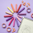 Colorful crayons arranged around sketchbook with drawing