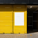 Empty white poster on vibrant yellow shutter door