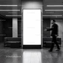 Blurred man walking past blank vertical billboard indoors