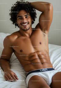 Smiling muscular man relaxing on bed in underwear