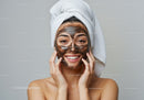 Smiling Woman with Brown Facial Mask and Towel Wrap