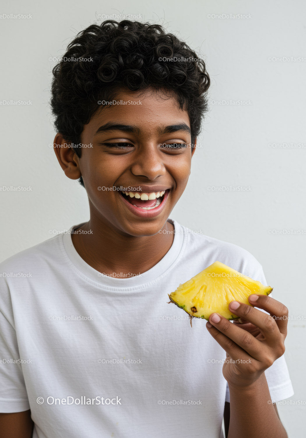 Joyful Boy Enjoying Fresh Pineapple Slice in Bright Indoor Setting