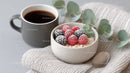 Fresh Frozen Berries in Ceramic Bowl with Coffee on Soft Textile