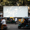 Busy street with auto rickshaws and pedestrians in motion