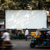 Busy street with auto rickshaws and pedestrians in motion