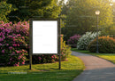 Empty wooden billboard surrounded by summer garden path