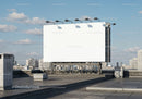 Blank billboard on urban rooftop under clear sky