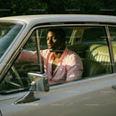 Young Man in Pink Shirt Sitting in Vintage Car on a Sunny Day
