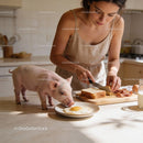 Young Woman Preparing Breakfast with Pet Pig in Kitchen