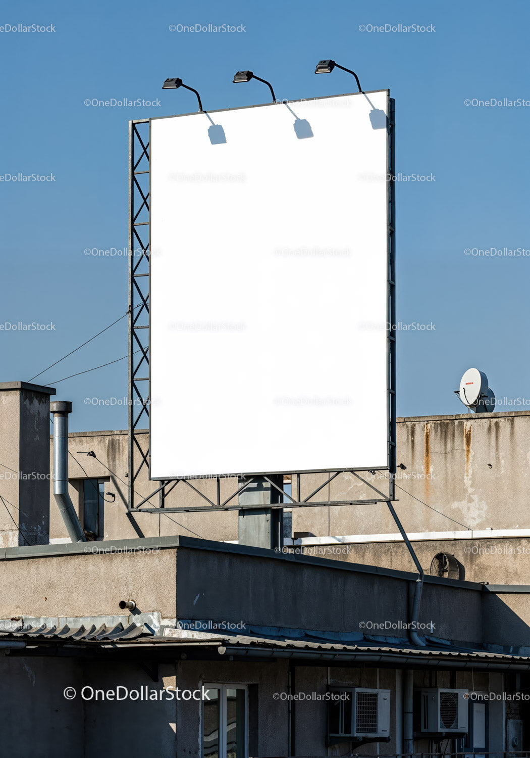 Empty billboard on urban rooftop under clear blue sky