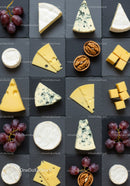 Assorted cheeses with grapes and walnuts on slate