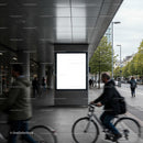Urban commuters cycling past large blank billboard