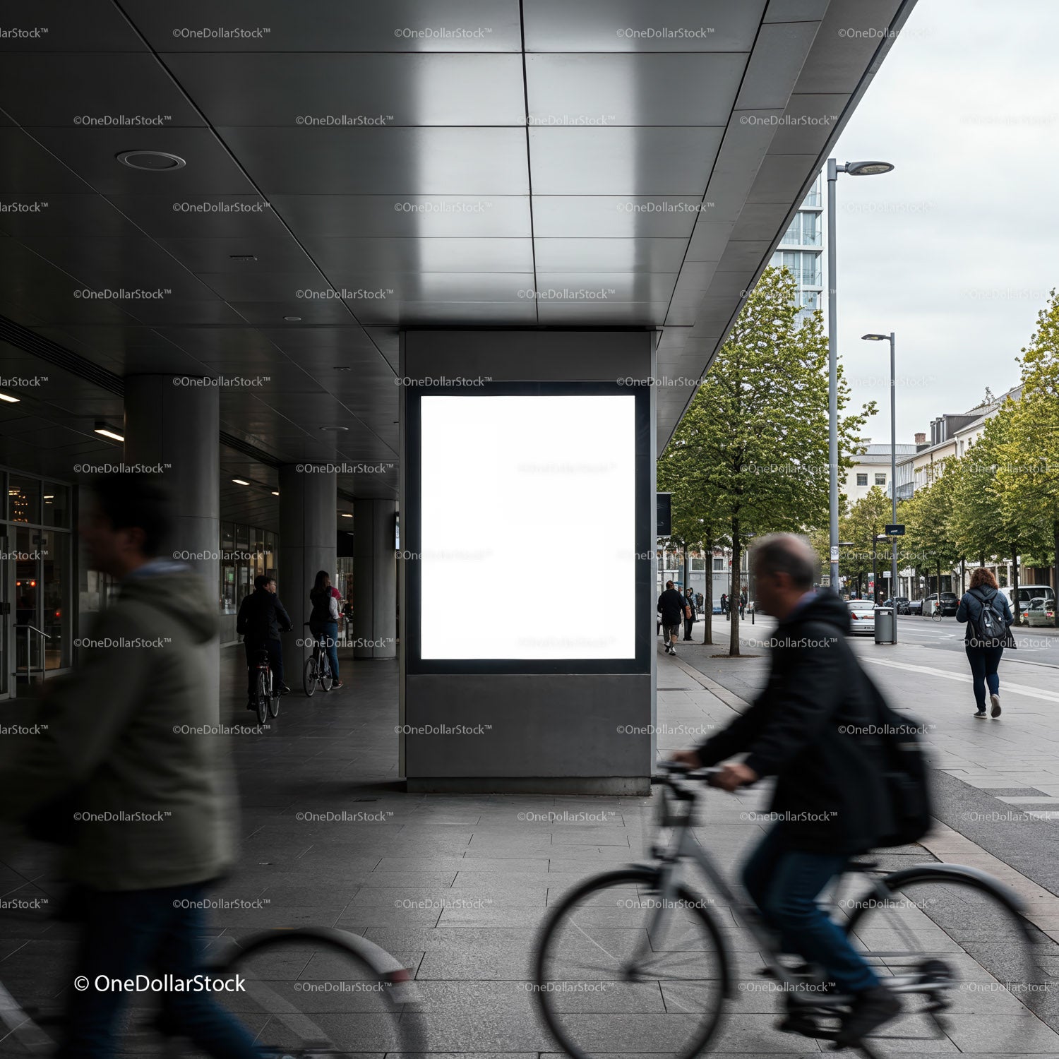 Dojeżdżający do pracy rowerzyści mijają duży, pusty billboard