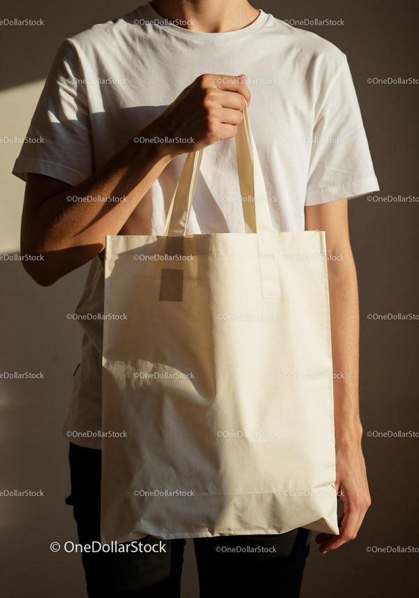 Person Holding Plain Canvas Tote Bag in Natural Light JPG Mockup Image